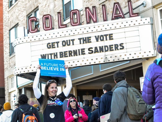 Kristan Tilton holds a sign for Sanders outside the