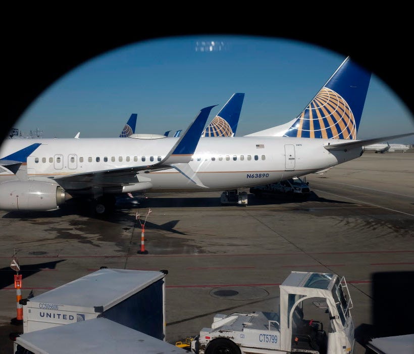 In this Nov. 22, 2017, photo taken through an aircraft passenger window, United Airlines planes are parked at a terminal at O'Hare International Airport in Chicago.