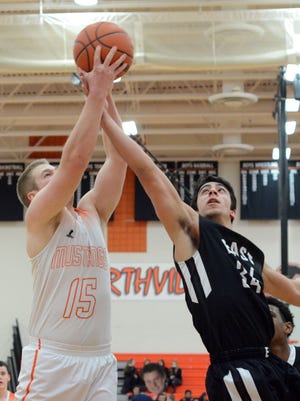 Northville's Michael Minick (left) battles for the rebound with South Lyon East's Sarkis Dagley during Friday's KLAA Central clash.