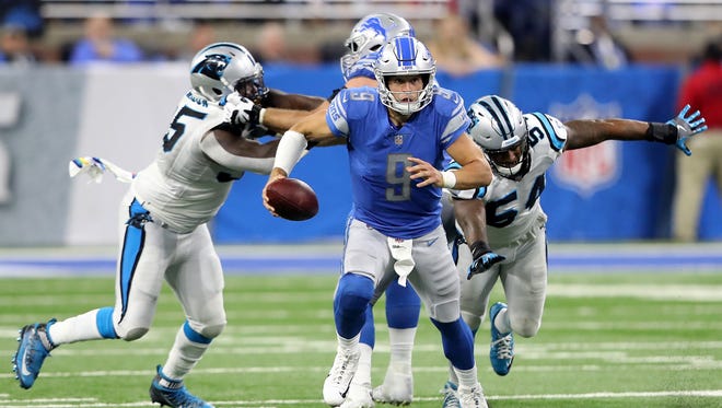 Matthew Stafford is chased by Panthers linebacker Shaq Thompson (54) in the fourth quarter of the Lions' 27-24 loss at Ford Field on Sunday, Oct. 8, 2017 in Detroit.