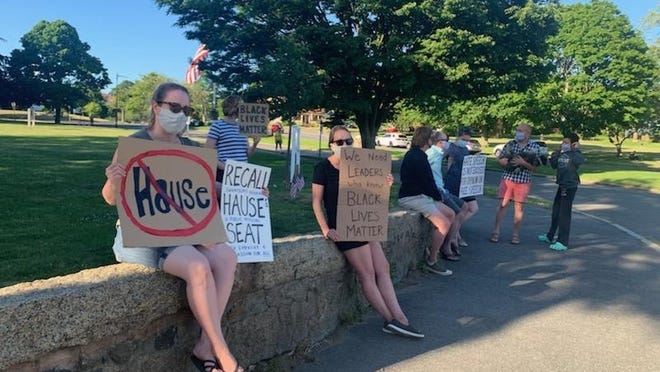 On Wednesday night, roughly 10 protesters stood outside Swampscott Town Hall, demanding the two-term Selectman Don Hause resign.