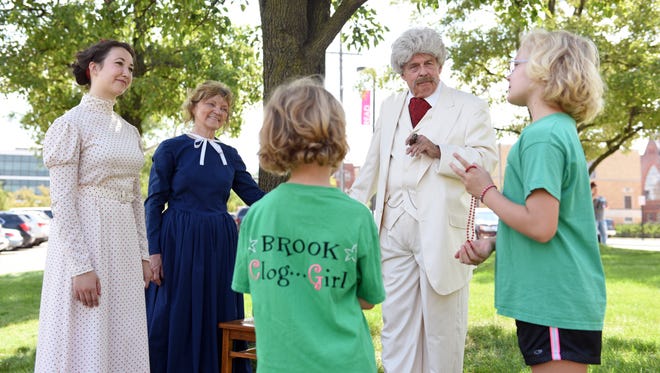 Courtney Burkhart, 9, and Brook Burkhart, 7, speak with Lew Woodward as Mark Twain, with the Zanesville Community Theatre, and townsfolk Michelle Jones and Diane Houston during the Mark Twain Family Fun Day on Saturday at John McIntire Library in Zanesville.