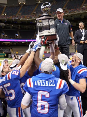 Louisiana Tech coach Skip Holtz hands the 2015 New Orleans Bowl trophy to his players at the end of last weekend's win over Arkansas State. The Bulldogs finish 2015 with a 9-4 record.