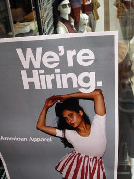 a sign says "we're hiring" at an American Apparel store in the downtown shopping district of Santa Monica, Calif. The Labor Department reports the number of people seeking U.S. unemployment benefits fell 10,000 last week to a seasonally adjusted 311,000, the lowest since late November and a hopeful sign hiring could pick up.