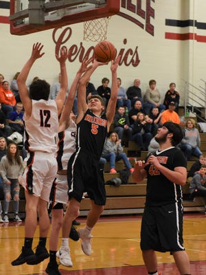 New Lex's Logyn Ratliff goes up for a shot against Crooksville's Caden Miller in Thursday's game. New Lex won 54-41. Miller, left, was named an honorable mention All-Ohio in Division III on Tuesday by the Ohio Prep Sportswriters Association.