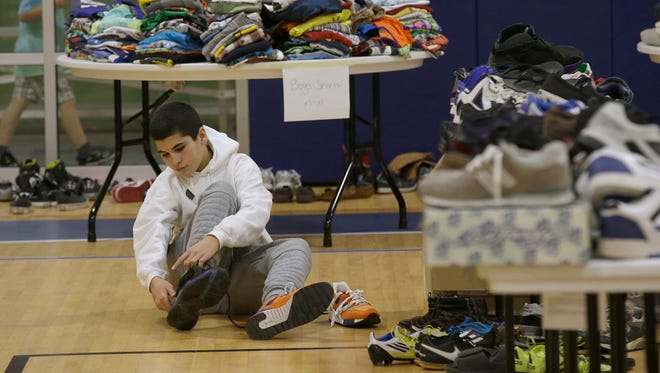 Mehdi Latrache tries on shoes at a donation center for victims of the recent wildfires, Tuesday, Oct. 17, 2017, in Santa Rosa, Calif. Latrache and his family lost their Coffey Park home a week ago as a massive wildfire swept through the area.