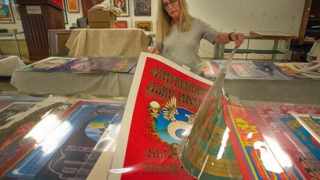 Cindy Stephenson looks through some of the 300-plus concert posters in the showroom while setting up for the auction of the Perry Pfeffer Estate Collection of Rock Concert Posters on Tuesday at Stephenson's Auctioneers & Appraisers in Upper Southampton.