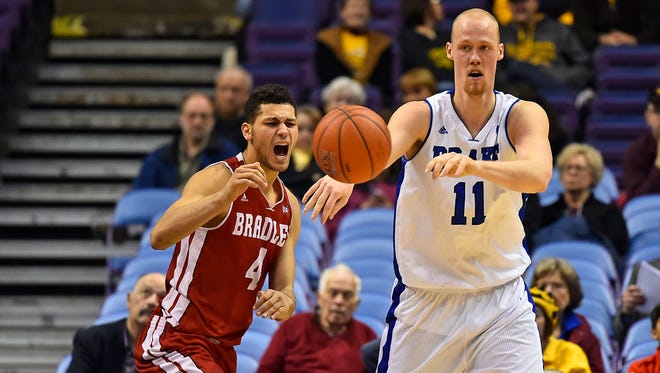 Drake Bulldogs center Jacob Enevold Jensen (11) passes the ball away from Bradley Braves forward Auston Barnes (4) in the second half during the first round of the Missouri Valley Conference Tournament at Scottrade Center. Bradley Braves won 52-50 in overtime.