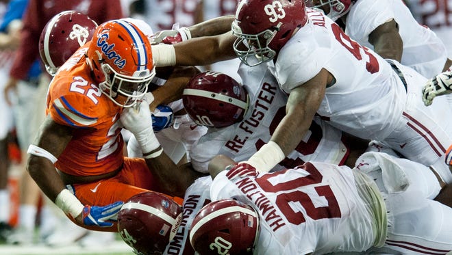 Florida running back Lamical Perine (22) is swarmed under by Alabama defensive back Minkah Fitzpatrick (29), linebacker Shaun Dion Hamilton (20), linebacker Reuben Foster (10) and defensive lineman Jonathan Allen (93) during the SEC Championship Game at the Georgia Dome in Atlanta, Ga. on Saturday December 3, 2016.
