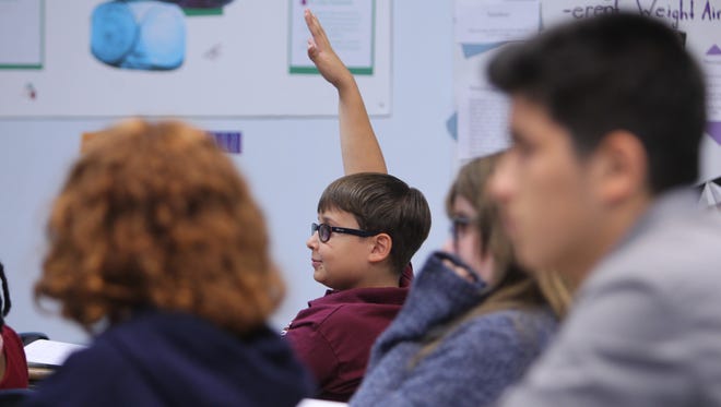 Robert Huff raises his hand during life science class at Sonoran Science Academy in Peoria on Oct. 28, 2015.