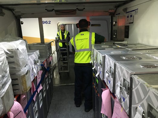 Workers stock the economy cabin with food and beverages