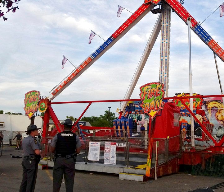 Authorities stand near the Fire Ball amusement ride after the ride malfunctioned injuring several at the Ohio State Fair, Wednesday, July 26, 2017, in Columbus, Ohio. Some of the victims were thrown from the ride when it malfunctioned Wednesday night