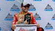 Kyle Larson and his son Owen kneel behind the pole