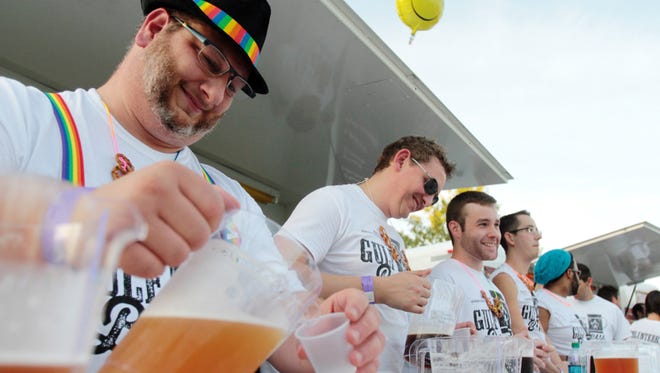 Dale Gauthier, left, and other volunteers serve samples at the Tin Roof Brewing Co. tent during Gulf Brew, a beer-tasting event benefitting the Acadiana Center for the Arts, Saturday, October 18, 2014, at Parc International in downtown Lafayette.