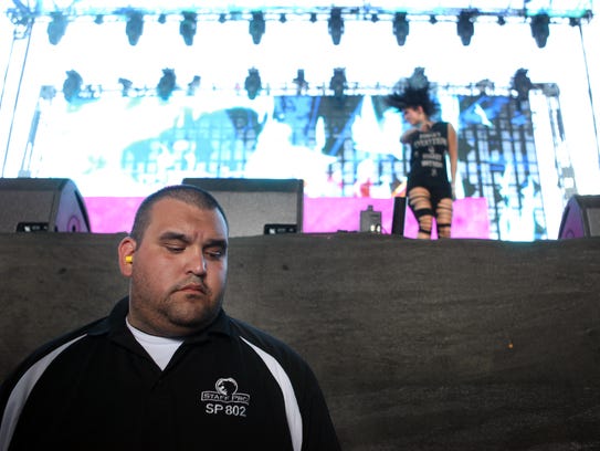 A security personnel stands in the photo pit as Krewella