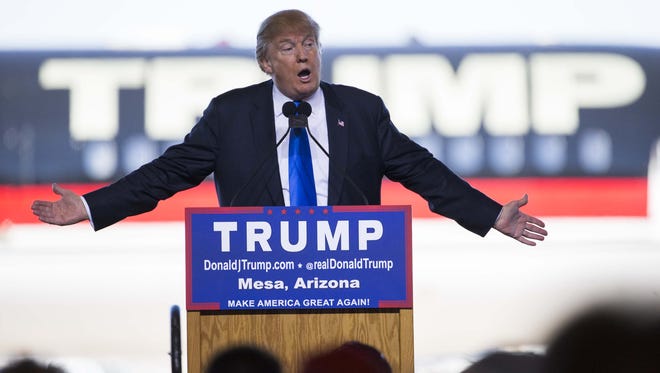 Then-Republican presidential candidate Donald Trump speaks during a campaign rally at Phoenix-Mesa Gateway Airport in 2015, with his jet behind him.