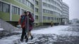 Two women walk outside a dormitory of the Kim Jong-Suk