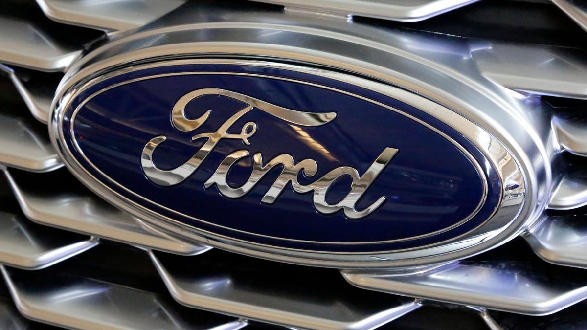 FILE- This Feb. 15, 2018, file photo shows a Ford logo on display at the Pittsburgh Auto Show. Ford is recalling more than 700,000 vehicles in North America because the backup cameras can show distorted images or suddenly go dark. The recall covers most 2020 versions of Fordâ€™s F-Series trucks, as well as the 2020 Explorer, Mustang, Transit, Expedition, Escape, Ranger and Edge.  The recall is expected to start Nov. 7, 2020.
