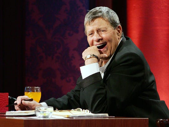 Entertainer Jerry Lewis laughs while watching a performer