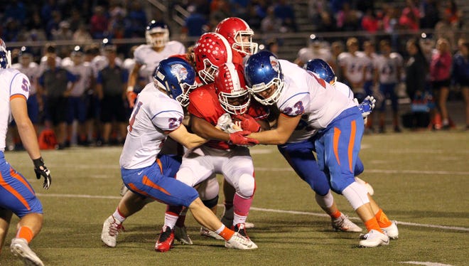 Whiteland defenders swarm Plainfield's ball carrier during the Warriors' 31-14 win Friday night.