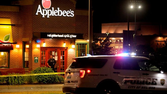 A police offer stands posted at the entrance of an Applebee's restaurant Monday, June 22, 2020, in St. John, Mo., a suburb of St. Louis. A gunman opened fire inside the restaurant, killing one and injuring at least two others, police said.