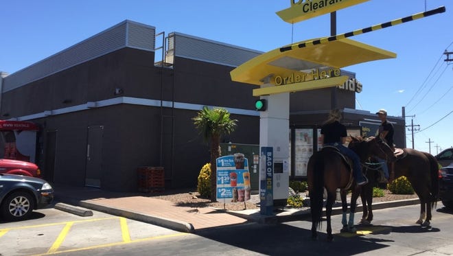 Megan Hall, right, and Edwen Aguayo each order ice cream while on horseback in the drive-thru lane at the Mesa Grande McDonald's on Thursday, May 11, 2017.