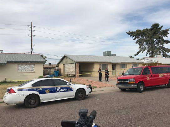 Police gather outside a north Phoenix home where a