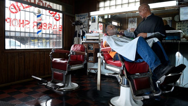 Barber Joe Trotter cuts Larry Tyner's hair at his Jefferson Street barbershop Thursday Feb. 25, 2016, in Nashville.