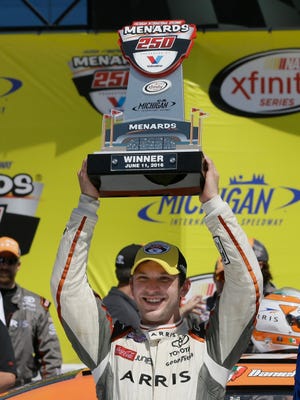Daniel Suarez holds the trophy after winning the NASCAR Xfinity series auto race at Michigan International Speedway, Saturday, June 11, 2016 in Brooklyn, Mich. The was the first win for Suarez. (AP Photo/Carlos Osorio)