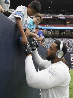 Stefan Charles of the Detroit Lions signs an autograph before a game against the Houston Texans on Oct. 30, 2016, in Houston.