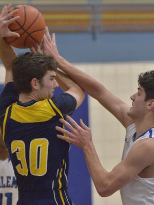 Battling it out for a rebound are South Lyon’s Jackson Curry (left) and Salem’s Kyle Winfrey.