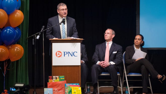 Dewey Hensley, Jeferson County Public Schools Chief Academic Officer addresses the audience as PNC Bank Regional President Chuck Denny, center, and Lyssa Ratliff, senior director of Save The Children, right, listen.24 March 2015