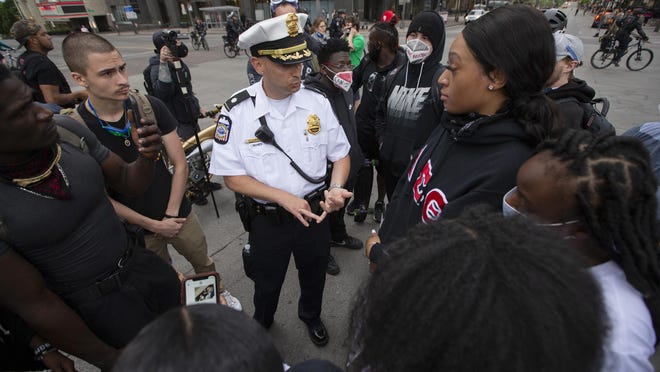 Columbus Police Cmdr. Robert Sagle speaks with a small group of protesters at the intersection of Broad and High Streets in Downtown Columbus on Monday.