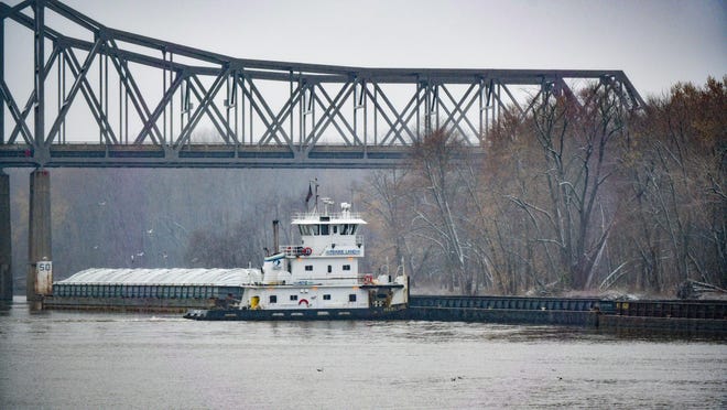 Barges float along the banks of the Illinois River near the Peoria Lock and Dam.
