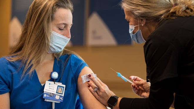 Alexa Zarlengo, R.N., receives a COVID-19 vaccine from Debbie Mahoney, R.N., at Ascension Saint Thomas Hospital West in Nashville, Tenn., Thursday, Dec. 17, 2020.