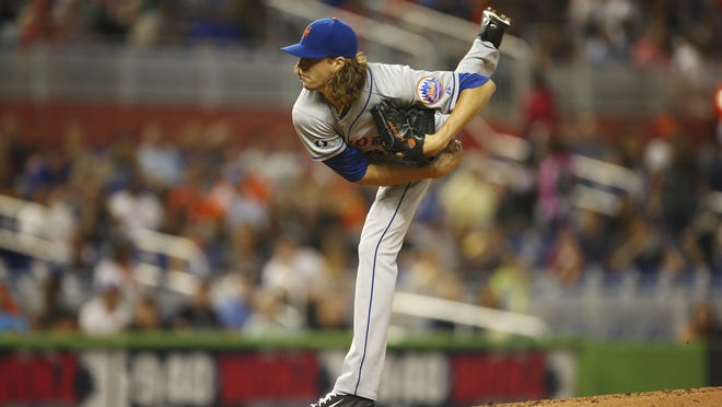 New York Mets starting pitcher Jacob deGrom throws during the first inning against the Miami Marlins on Saturday. The rookie pitched seven scoreless innings to earn his first win.