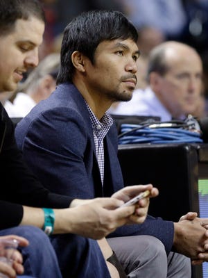 Boxer Manny Pacquiao watches the game between the Miami Heat and the Milwaukee Bucks on Tuesday night.