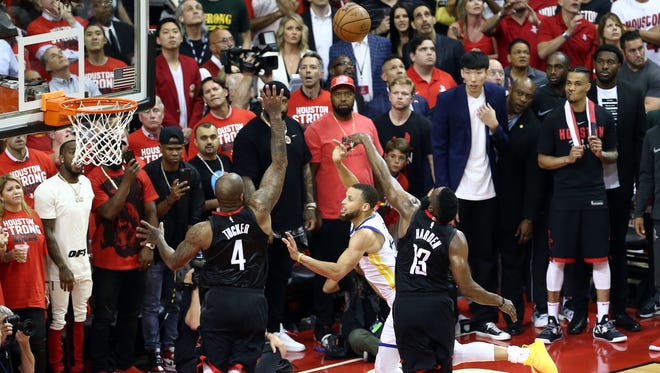 James Harden (13) and P.J. Tucker (4) force Steph Curry (30) into a wild off-balance shot.