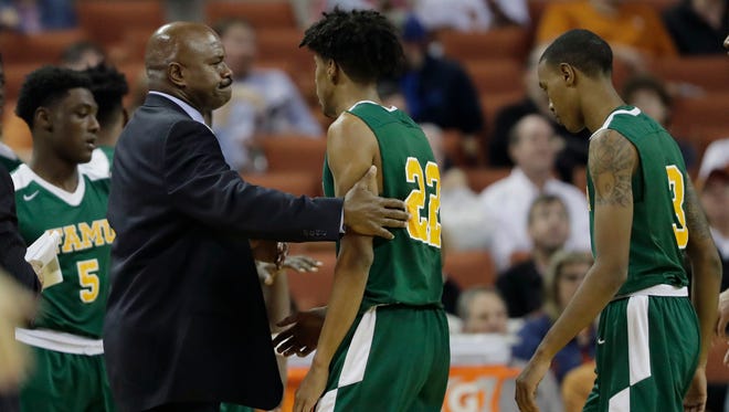 Florida A&M coach Robert McCullum, left, greets guards Marcus Barham (22) and Craig Bowman (3) as the head to the bench during a timeout in the second half of an NCAA college basketball game against Texas, Wednesday, Nov. 29, 2017, in Austin, Texas. Texas won 82-58. (AP Photo/Eric Gay)