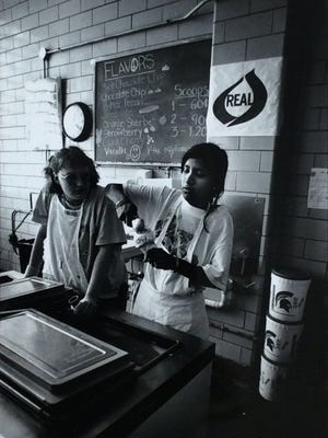Julie Buck, left, watches MSU graduate student Krishnakali Majumdar scoop ice cream for customers at the MSU Dairy Store in 1999.