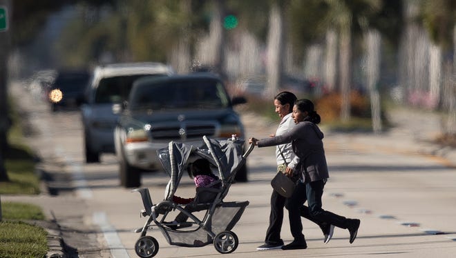 Pedestrians cross Palm Beach Boulevard on Tuesday. The Cape Coral-Fort Myers  area has been deemed the most dangerous metro area in the U.S. for walking. These women did not use a crosswalk.  