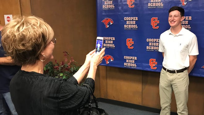 Mici Graham takes a photograph of her grandson, Joshua Graham, following the student's reveal as the 15th ranked member of Cooper High School's Class of 2018 during a ceremony at the school Monday.