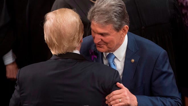 US President Donald Trump embraces US Senator Joe Manchin, Democrat of West Virginia, after speaking during the State of the Union Address before a Joint Session of Congress at the US Capitol in Washington, DC, January 30, 2018.