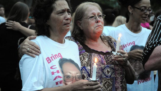 Lynnette Mitchell, right, hugs Angie Robinson, mother of Tameka Lynch, during Thursday evening’s candlelight vigil at Yoctangee Park.