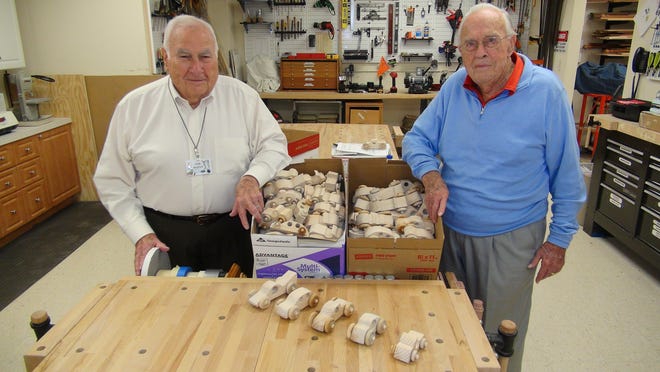 Don Bouffard (left) and Casey Rost worked together in Fox Run’s hobby shop to make about 200 wooden toy cars that they are donating to Toys for Tots.