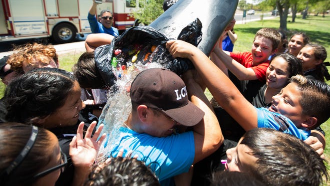 Jaime Montoya, Las Cruces Police Chief, gets a bucket of water dumped on him by the campers at the LCPD Youth Leadership Summer Camp after a water balloon fight between campers and officers Thursday, June 29, 2017, at Young Park.
