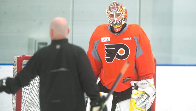 Brady Robinson, left, is the Flyers' goalie development coach and travels the globe following and instructing their prospects between the pipes.