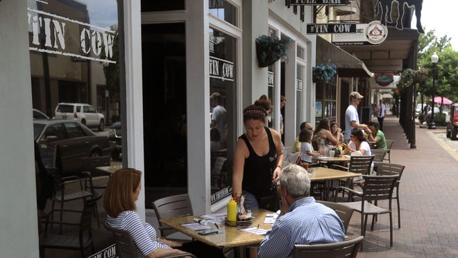 Diners eat at The Tin Cow during Shop Sunday in downtown Pensacola.
