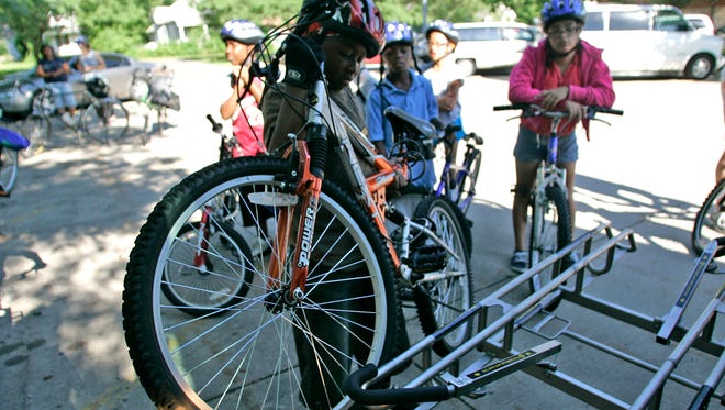 A youngster learns how to properly attach his bike to the front rack of a DART bus.