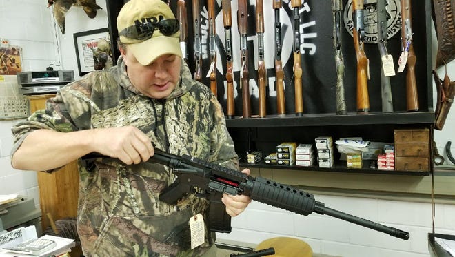 Brock Kimmet with an Armalite 15, otherwise known as an AR-15 weapon semi-automatic rifle used for sport shooting or hunting.